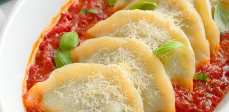 Pierogi ze szpinakiem i trzema serami zapieczone w sosie pomidorowym