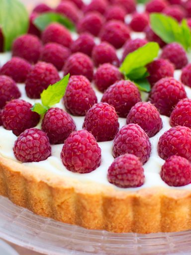 Tarta z kremem z białej czekolady i malinami