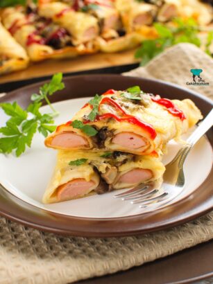 Parówki zapiekane w naleśnikach z pieczarkami