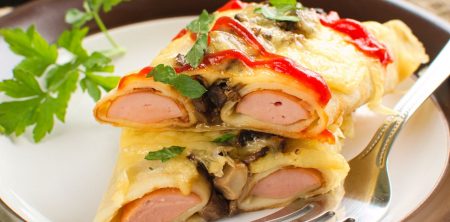 Parówki zapiekane w naleśnikach z pieczarkami