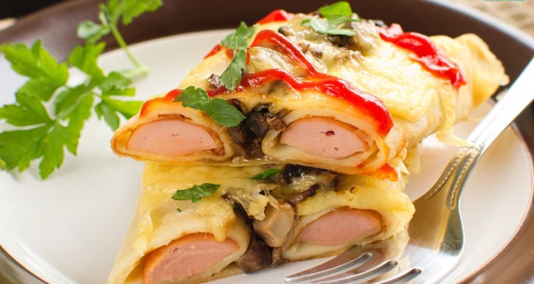 Parówki zapiekane w naleśnikach z pieczarkami